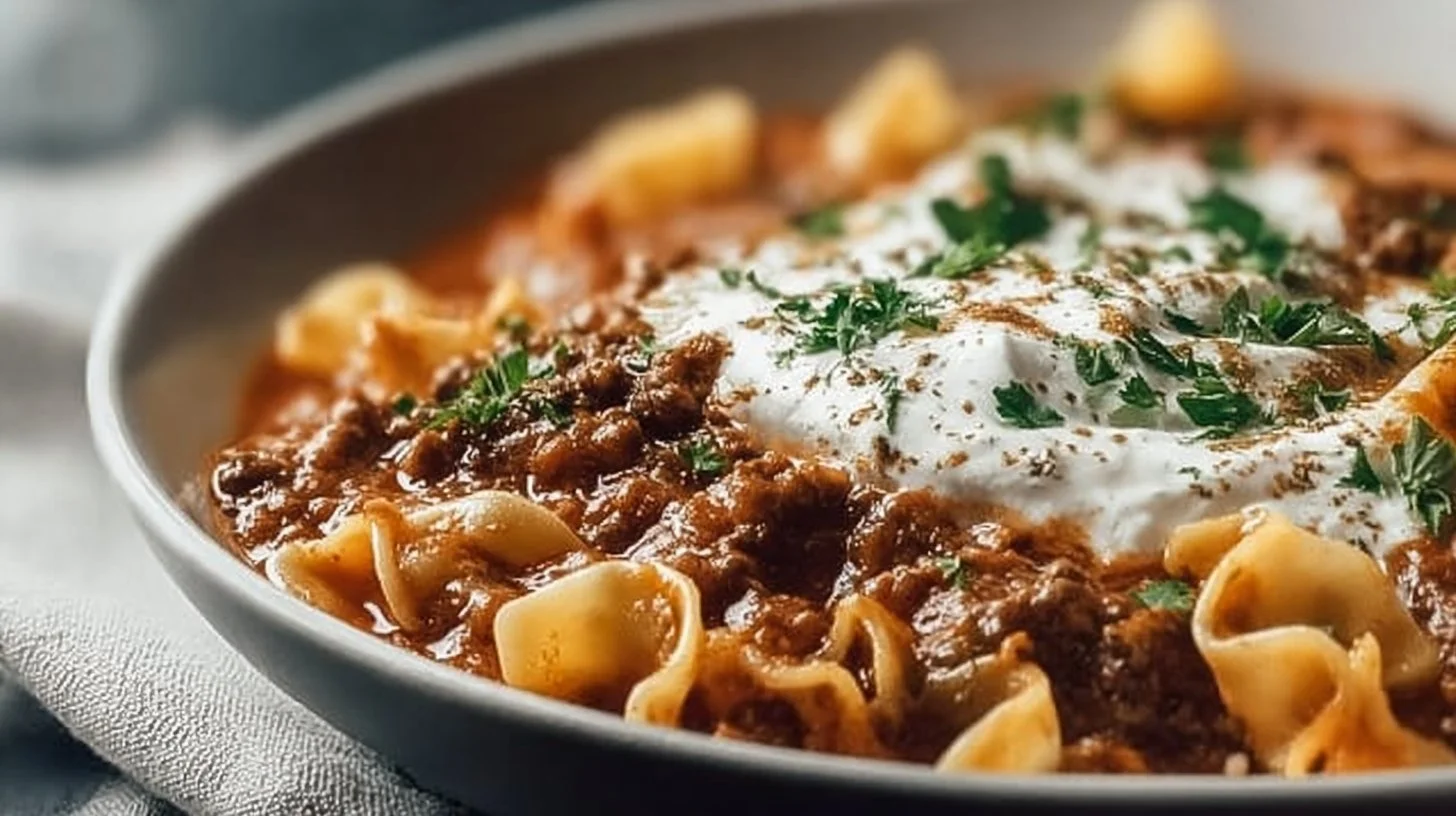 A delicious bowl of hearty slow cooker lasagna soup topped with cheese and herbs.