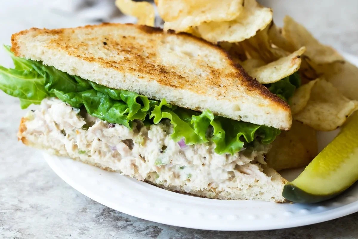 Bowl of creamy and fresh tuna salad with vegetables and herbs